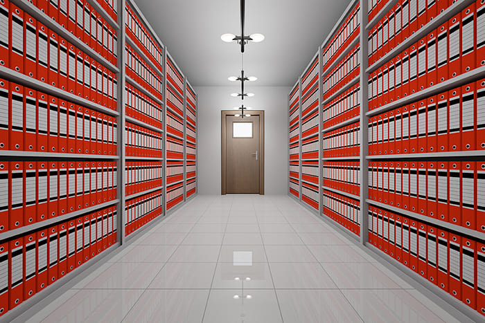 Salle d'archive avec rayonnages de chaque côté d'une porte